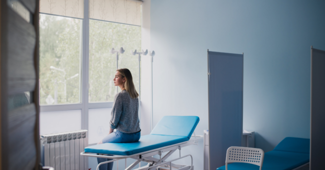 patient sits on chair and contemplates beliefs