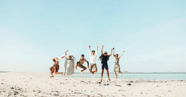 Group of friends jumping excitedly on a beach